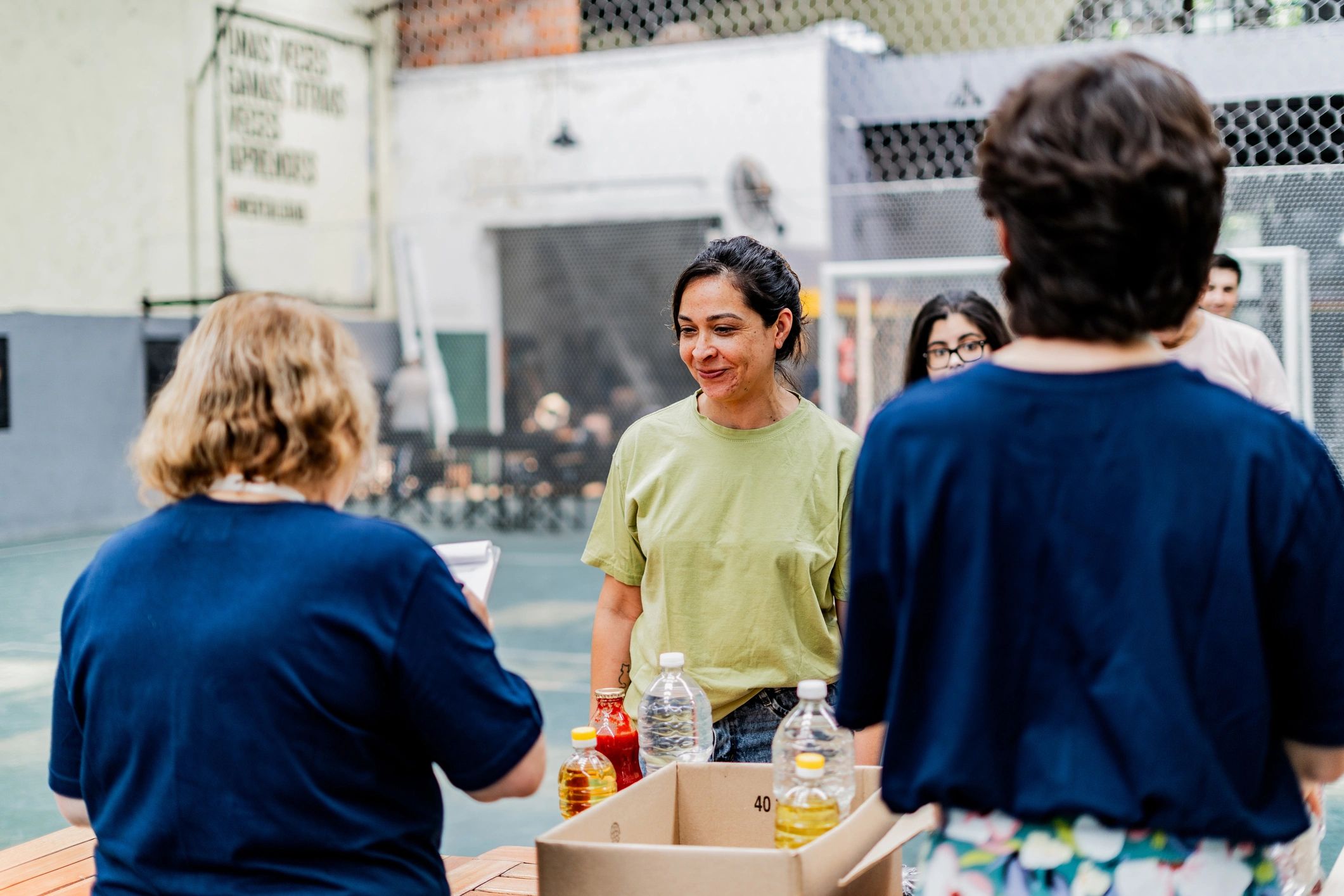 Community member speaking with a volunteer at a donation center